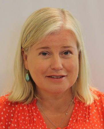 Kvinne med lyst skulderlangt og orange bluse - Klikk for stort bilde